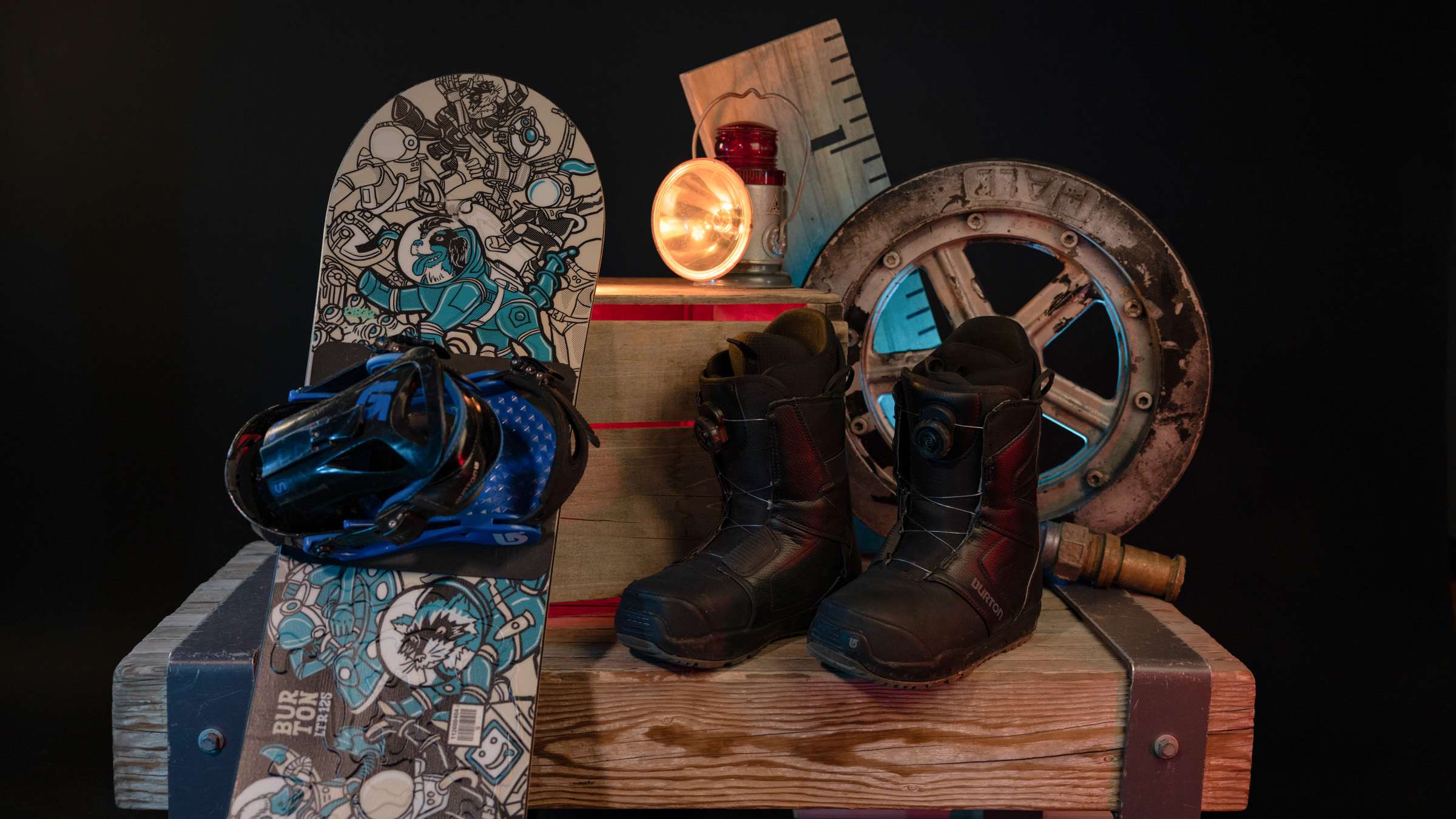 Snowboard with bindings and boots displayed on wooden table