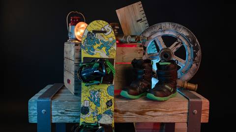 Snowboard with bindings and boots displayed on wooden box