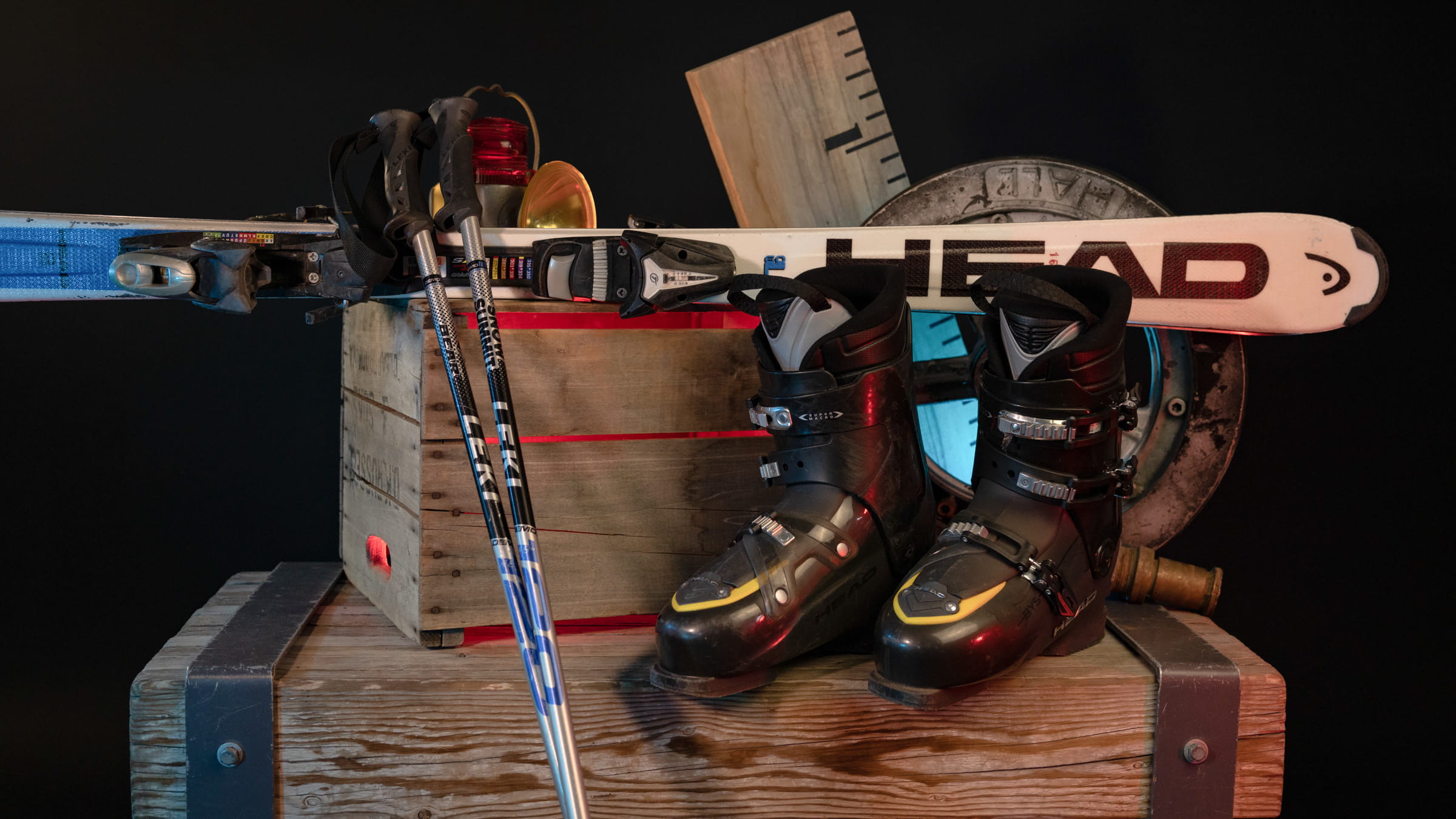 Ski boots, poles, and skis displayed upon a wooden box