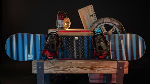 Snowboard with bindings leaning against a wooden box