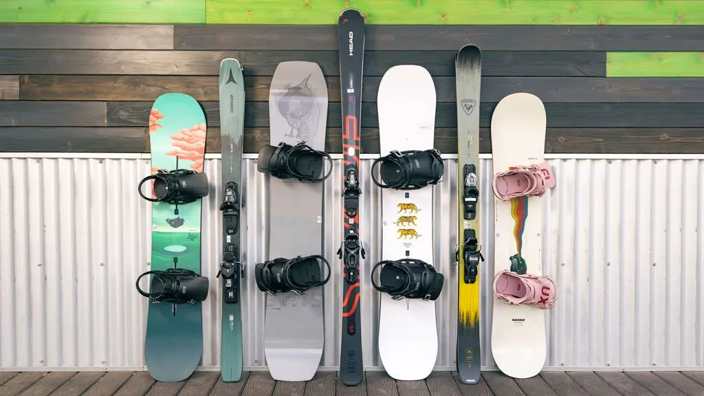 Demo skis and snowboards leaned up against a building at Snow Summit.