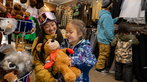 mom and daughter a snow summit's sports shop shopping for a teddy bear plush