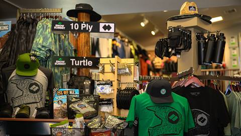 Big Bear Sports retail store in the base area of Snow Summit with summer items including hats, shirts, trail signs, and more.