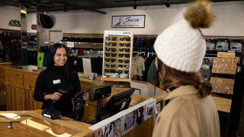 Snow Valley employee helping out a customer to purchase retail items in the Snow Valley sports shop