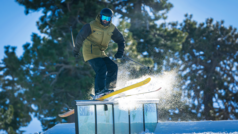 skier hitting a rail and grinding on it