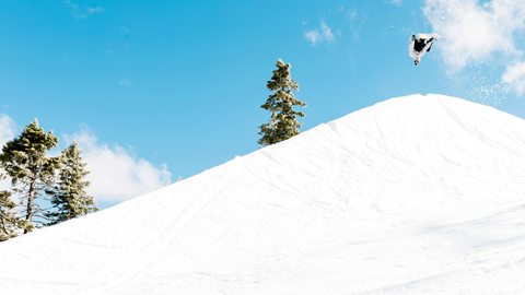 Snowboarder doing a flip off the quarterpipe at Bear Mountain