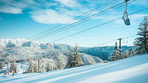 Snow Valley chairlift and groomed run shot on a blue bird day