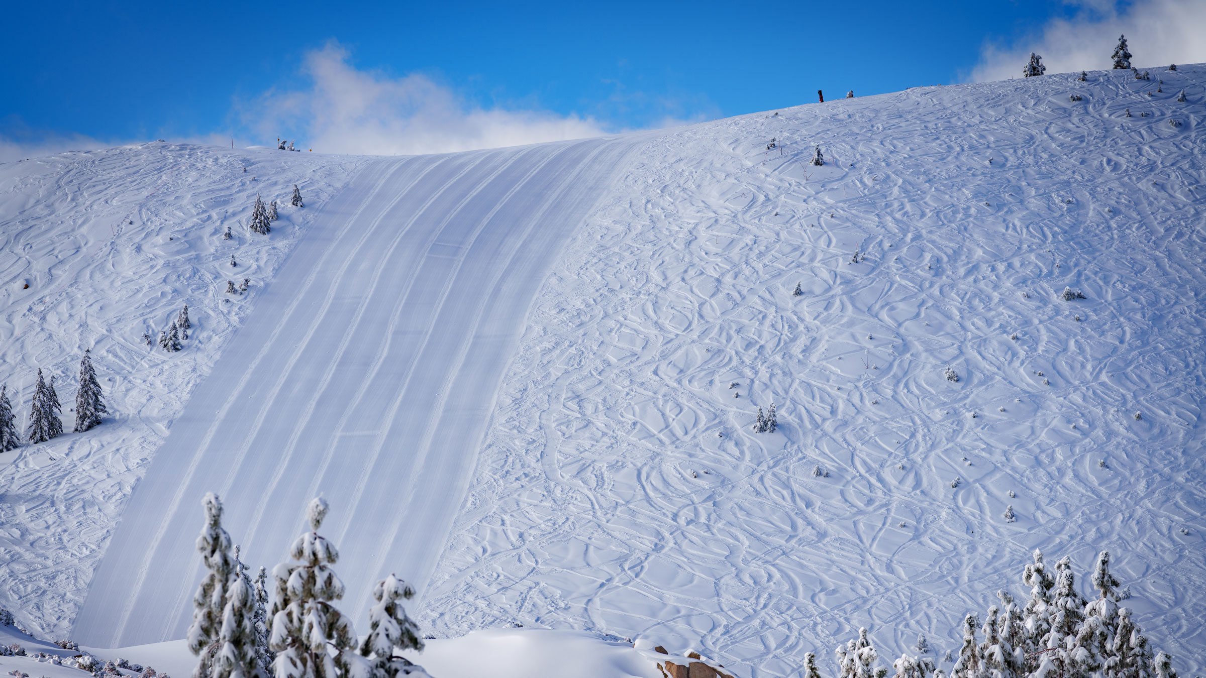 Snow Valley's Slide Peak after a fresh snowfall with a groomed face run and also ski and snowboard turns in fresh powder