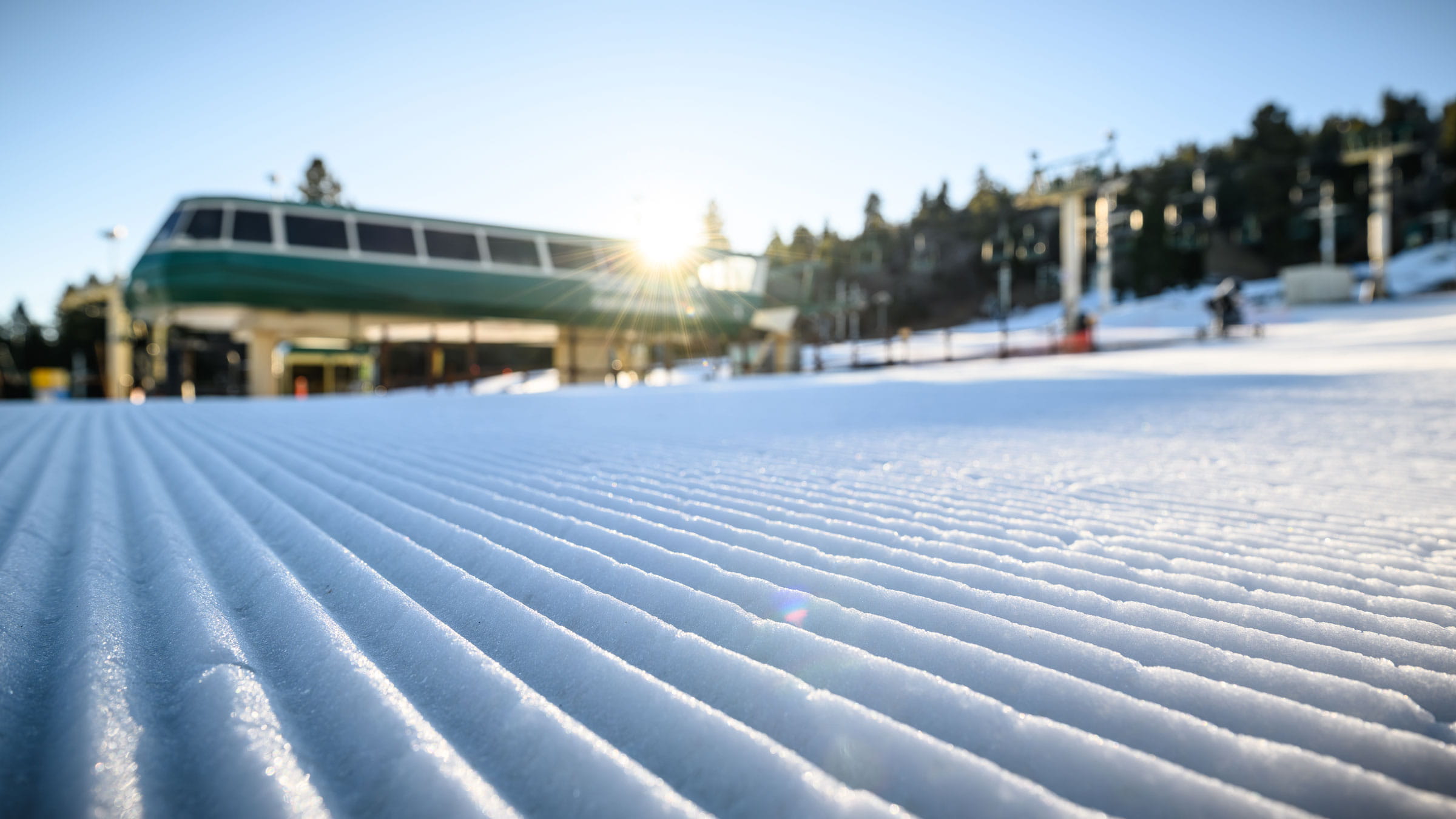 Corduroy snow at the base area of Snow Summit with ski lift in background