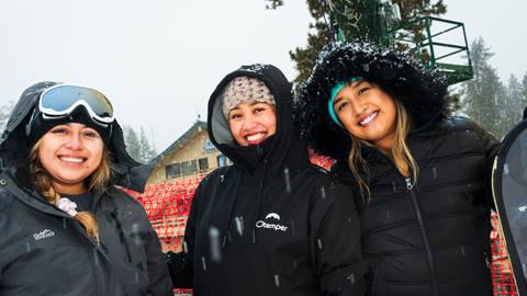 Three adults in dark outerwear at Snow Valley enjoying the new snow