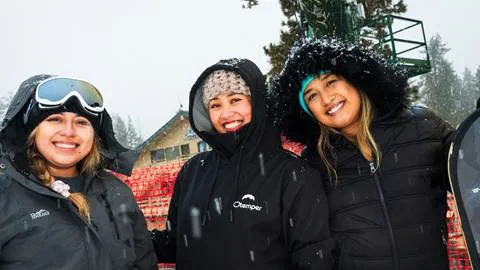 Three adults in dark outerwear at Snow Valley enjoying the new snow