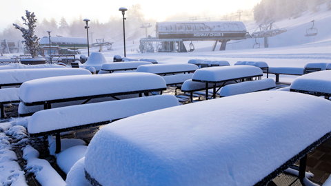 Untouched fresh snow on the tables and seating in the base area of Bear Mountain.