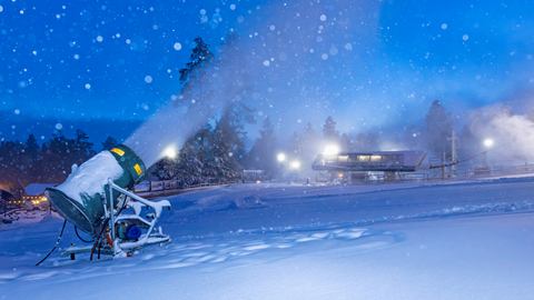 A snow gun that is turned on and blowing man-made snow during a snowstorm in the base area at Snow Summit.