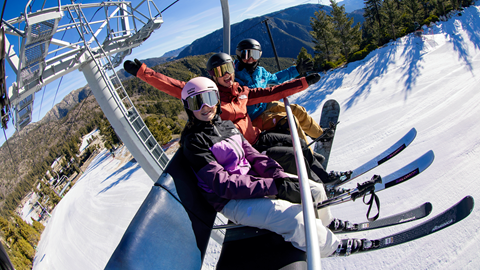 group of ski and snowboarding friends on a chairlift