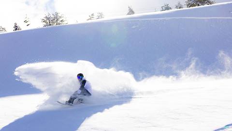 Snowboarder slashing in fresh powder