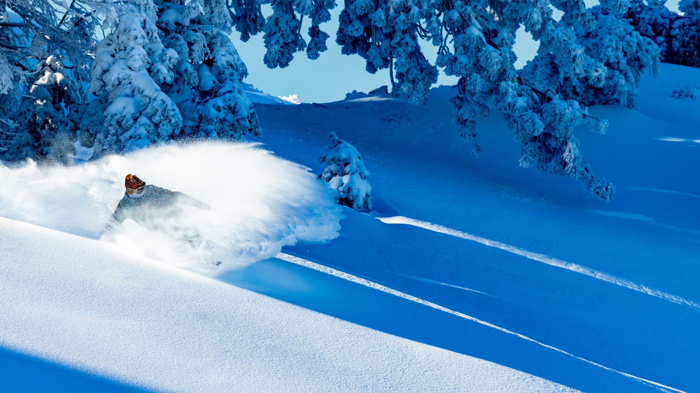 powder show by snowboarder on a bluebird day at BBMR