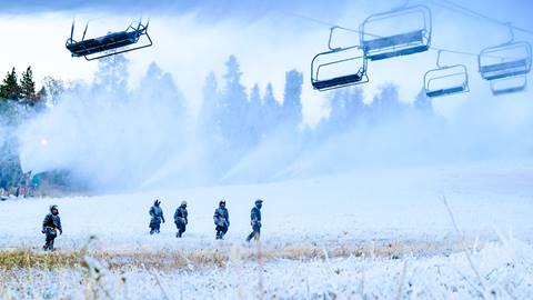 Snowmaking underway while employees check the ski hill.