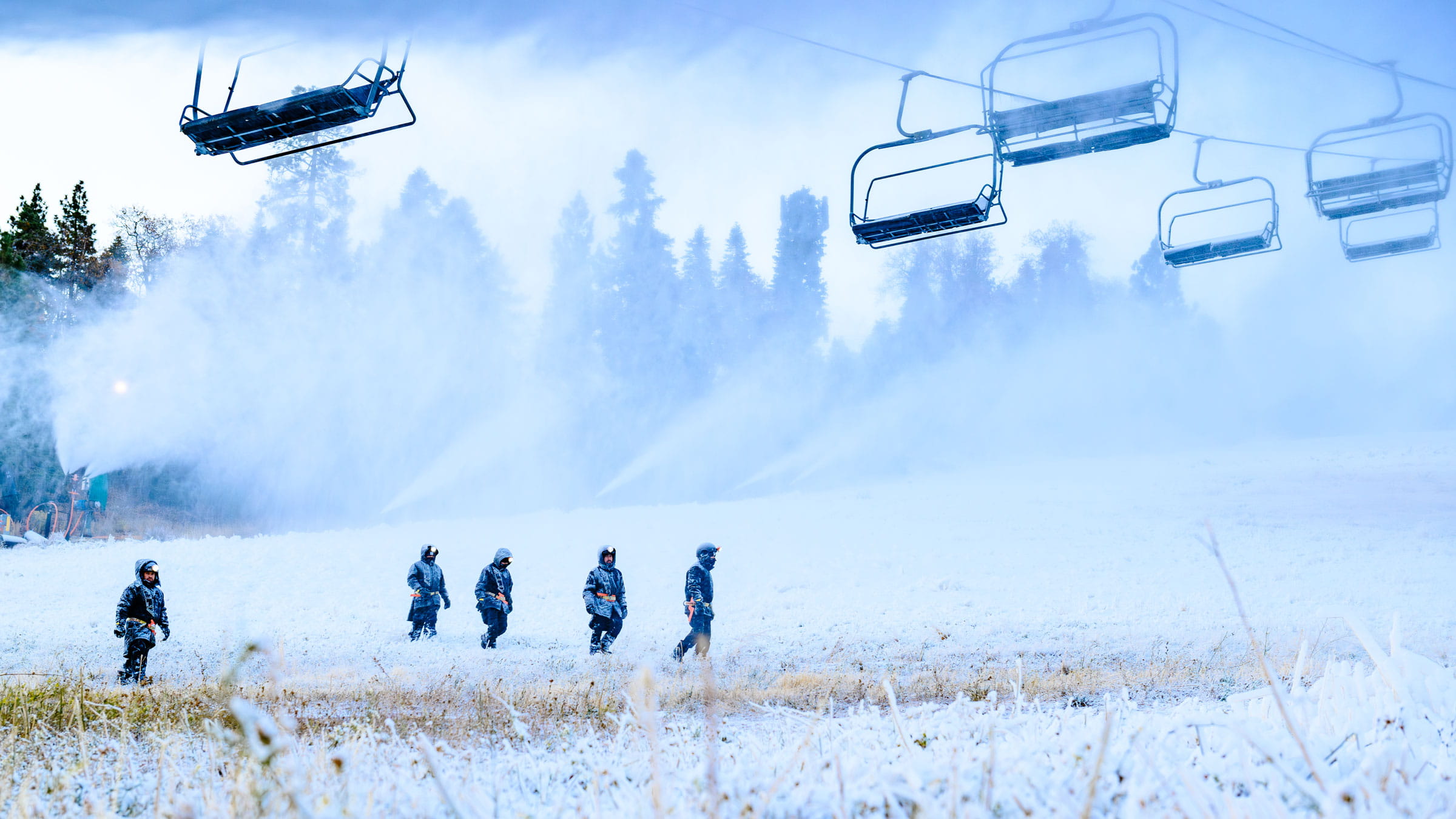 Snowmaking underway while employees check the ski hill.