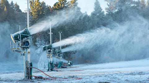 Snowmaking guns blowing snow onto the ski hill.