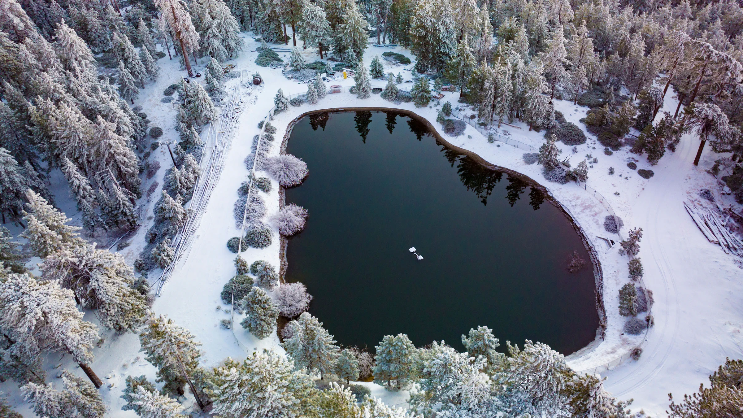 drone view of water in a snowy mountain surrounding