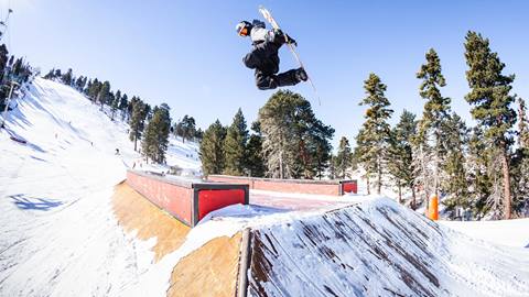 Snowboarder doing a trick on a feature