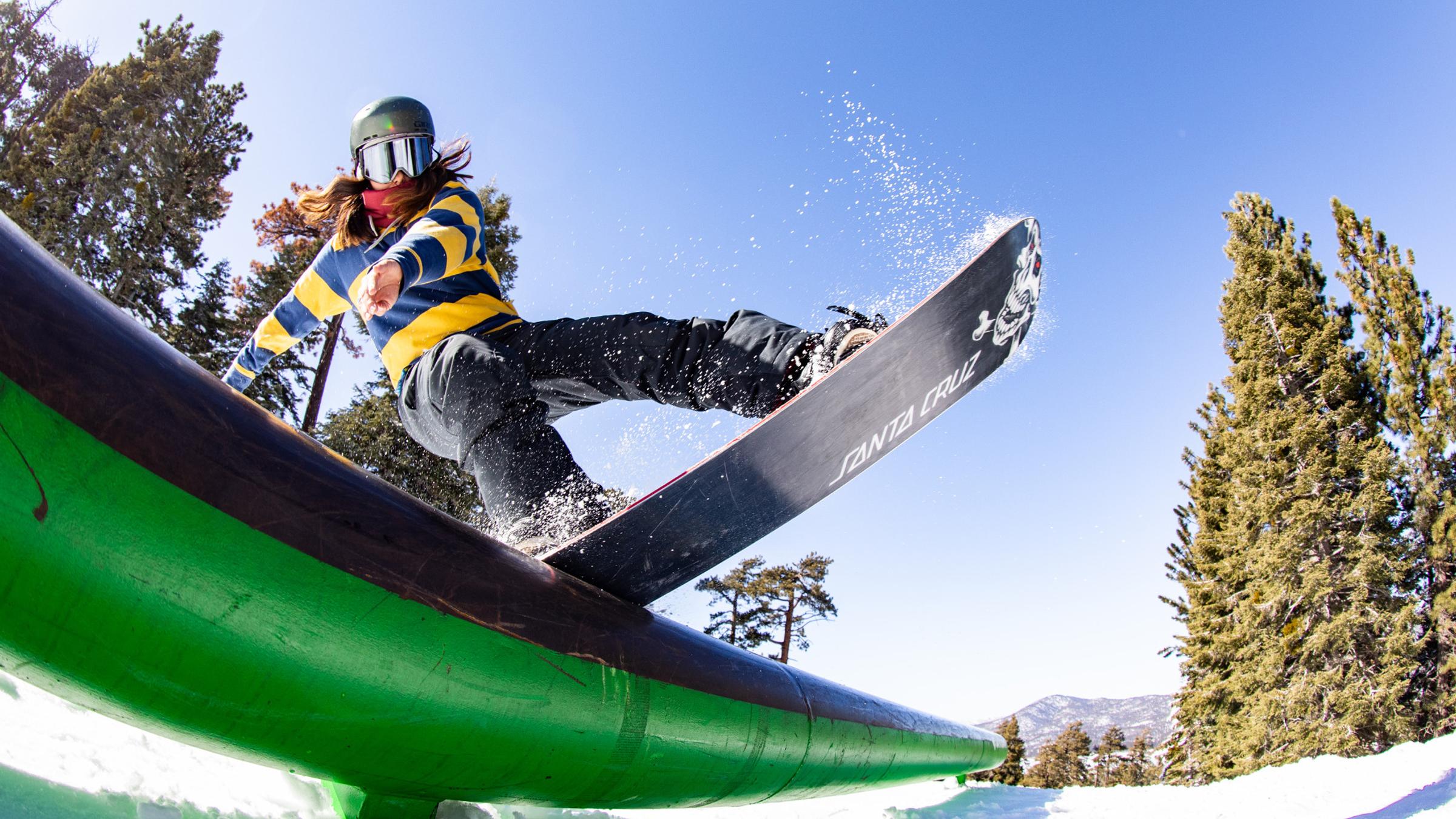 Snowboarder on a green rail feature