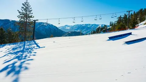 Two black rail terrain park features in the snow at snow valley in the winter