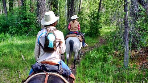 Two people horseback riding