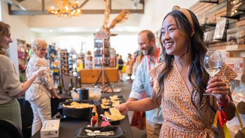 Adult with long brown hair in a dress inside a shop within The Village at Big Bear Lake during a city wine event.
