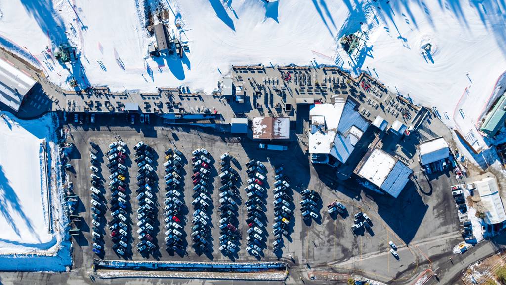 Drone photo of Bear Mountain Base Area including sun deck and parking lot.