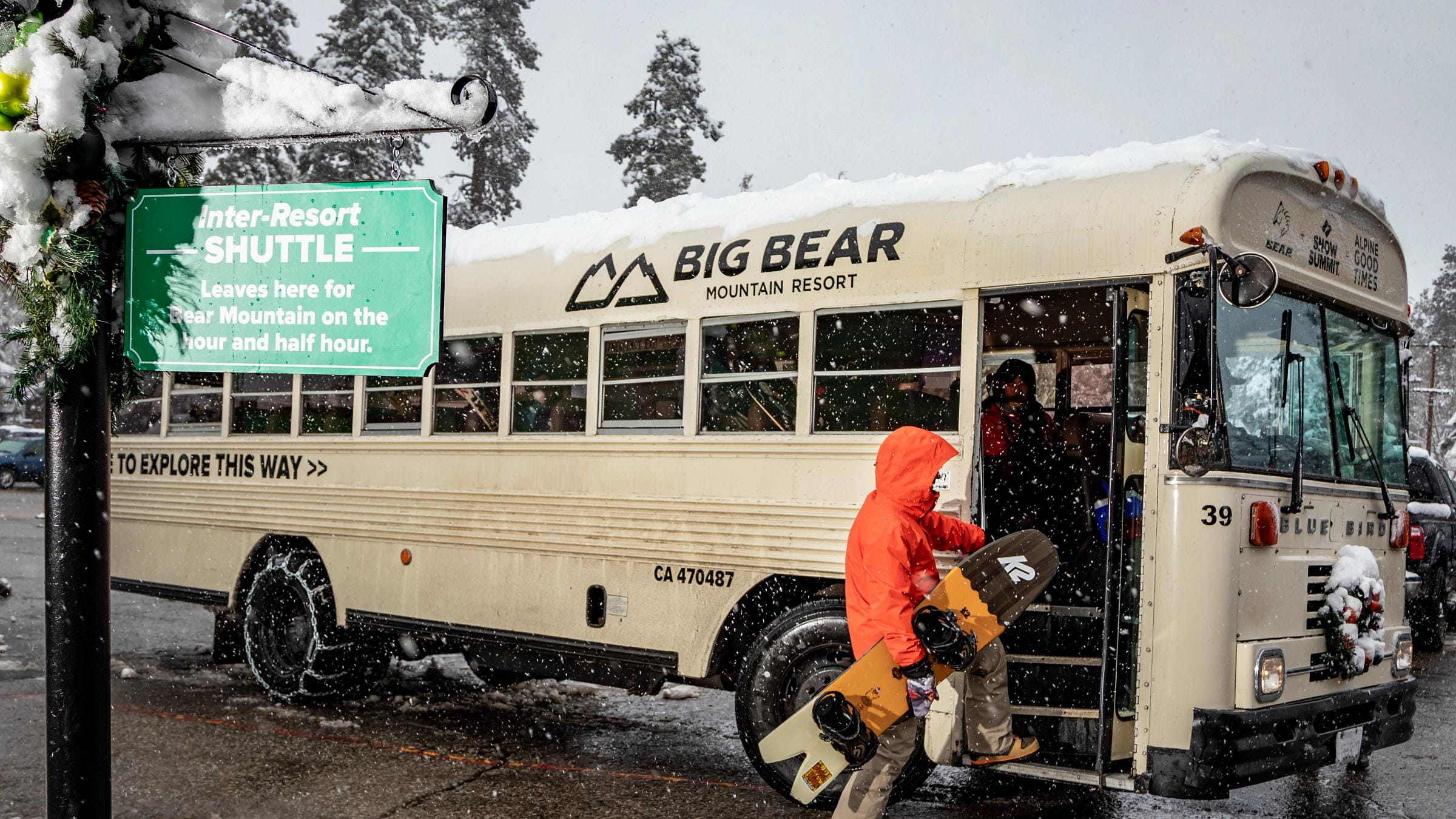Snowboarder loading into a shuttle bus