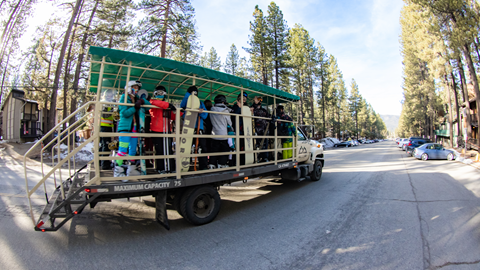 cattle shuttle with skiers and snowboarders on it headed towards snow summit ski resort