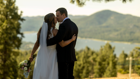 Bride and groom kissing with big bear lake in the background