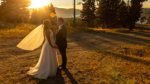 Bride and groom during sunset hour at the top of the mountain at snow summit