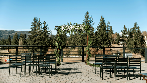 Wedding ceremony chairs and arch set up on an outdoor deck