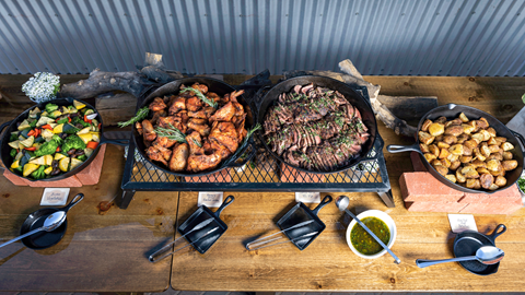 Meat and veggies catered meal displayed on a long table