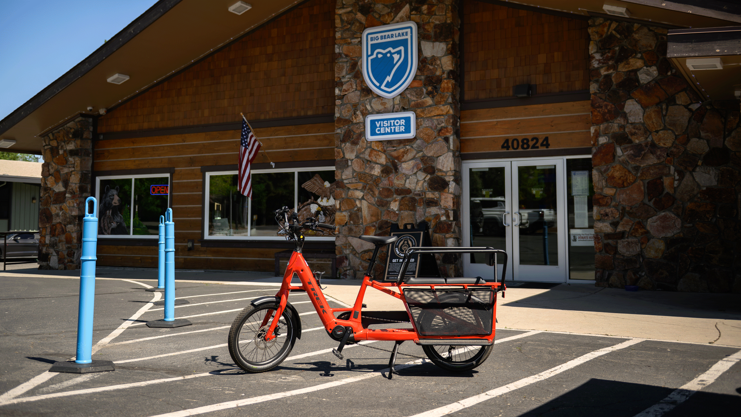 A red Trek branded eBike with a double seater kid carrier on the back.