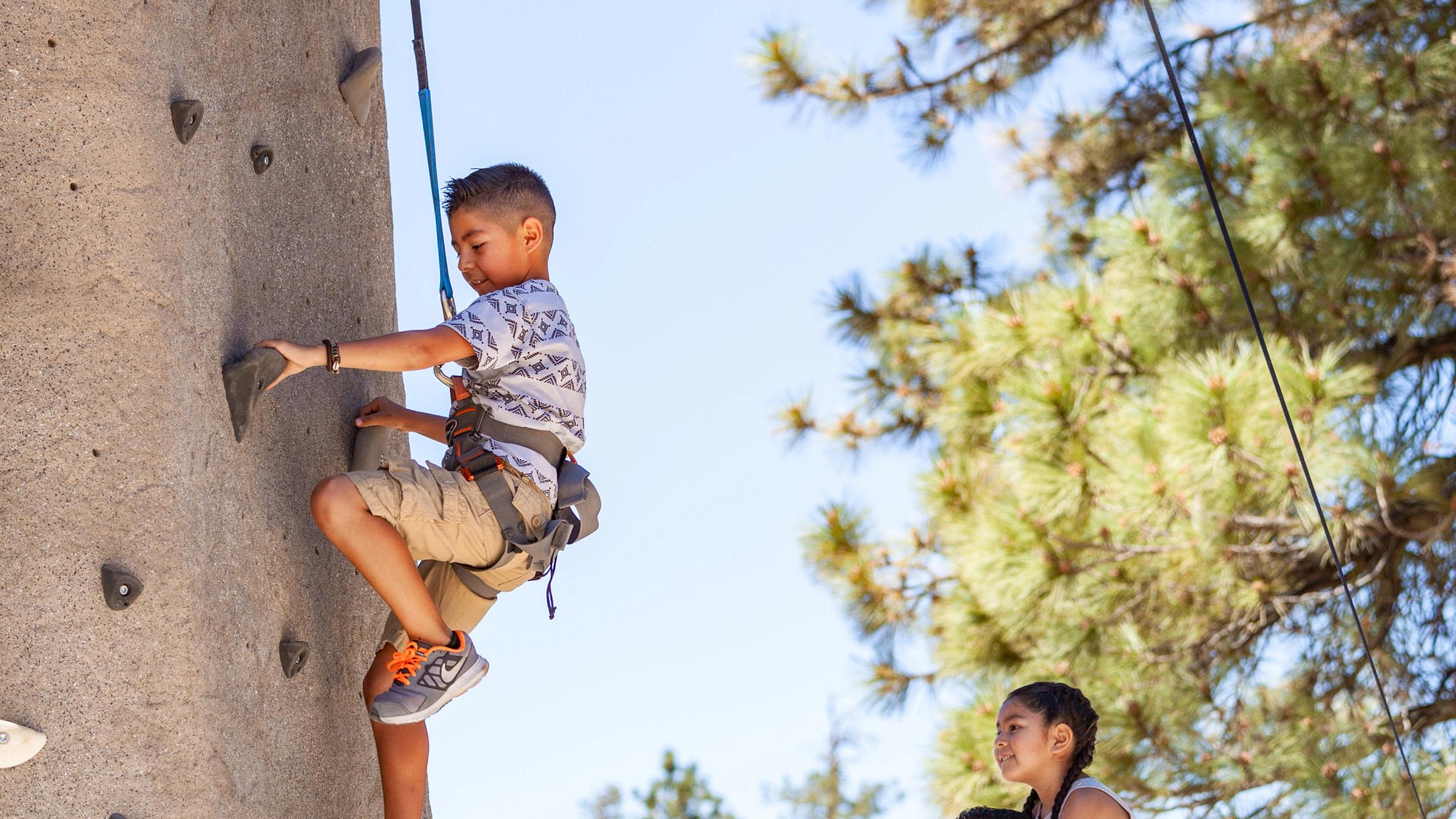 kid on an outdoor rock wall